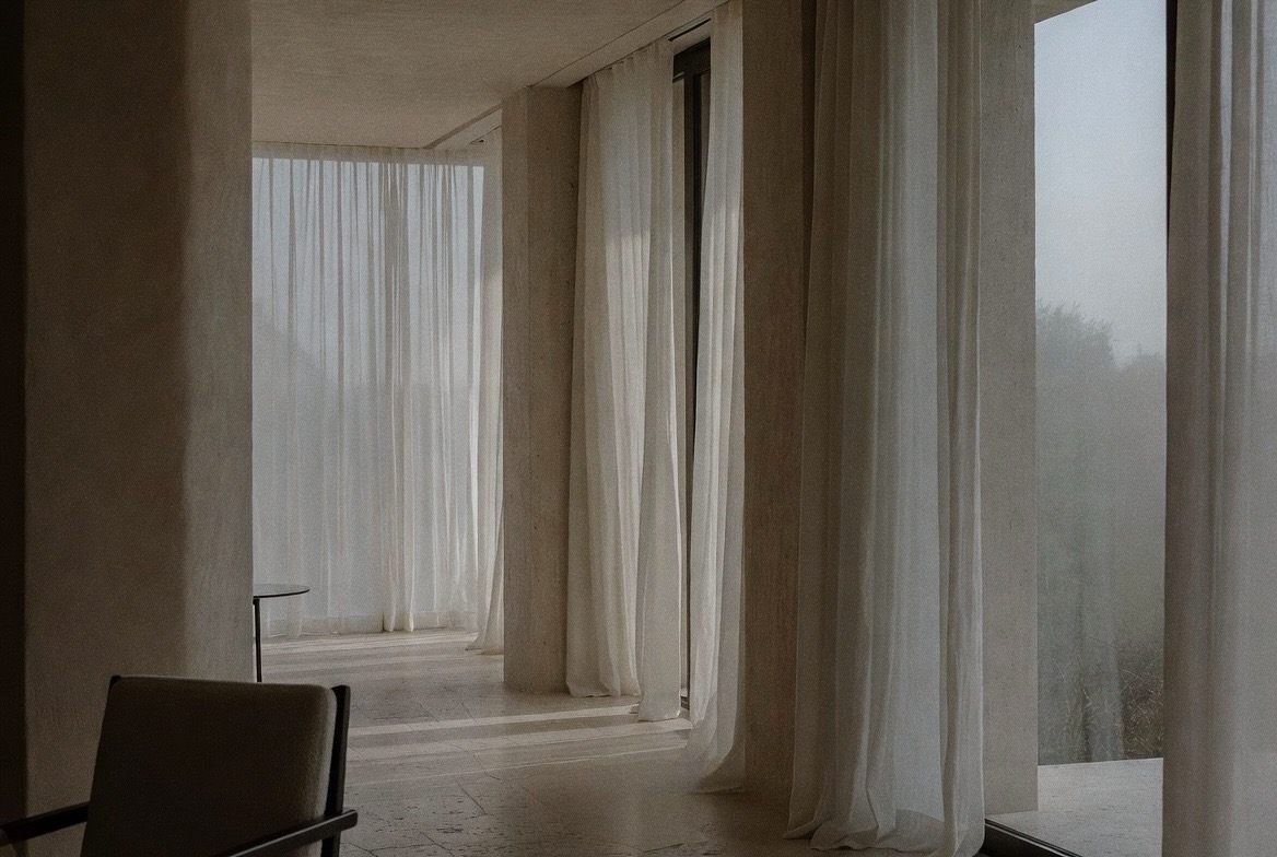Sheer linen curtains in a limestone interior