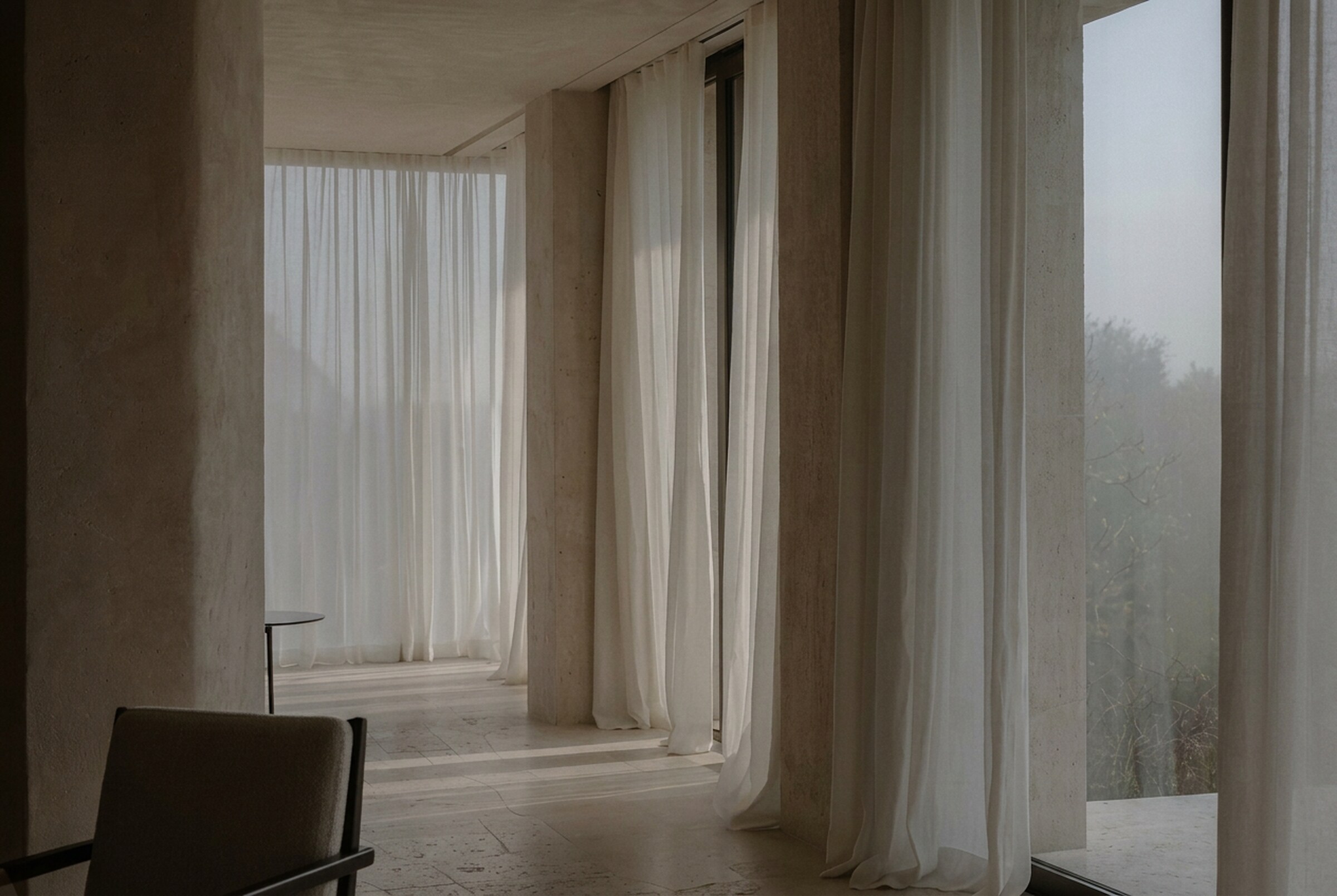 Sheer linen curtains in a limestone interior